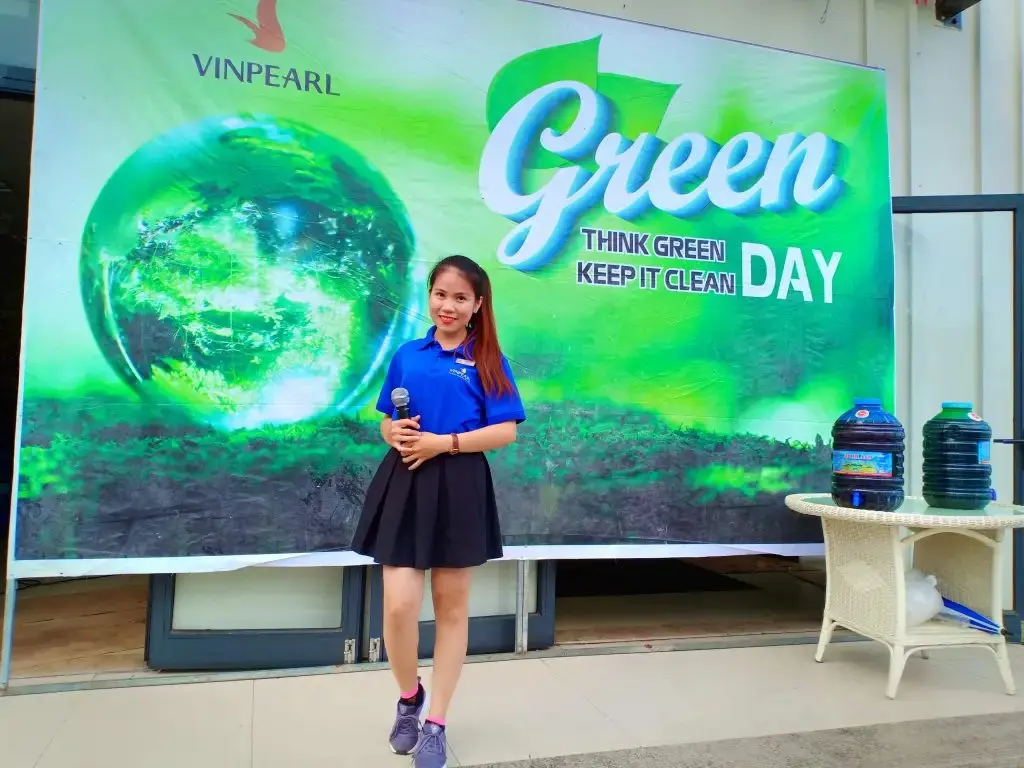 Loo cầm mic dẫn chương trình Green Day trước phông xanh