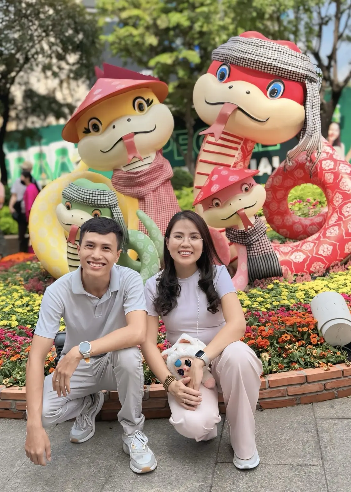 Loo và Boo ngồi trước tượng rắn trang trí Tết