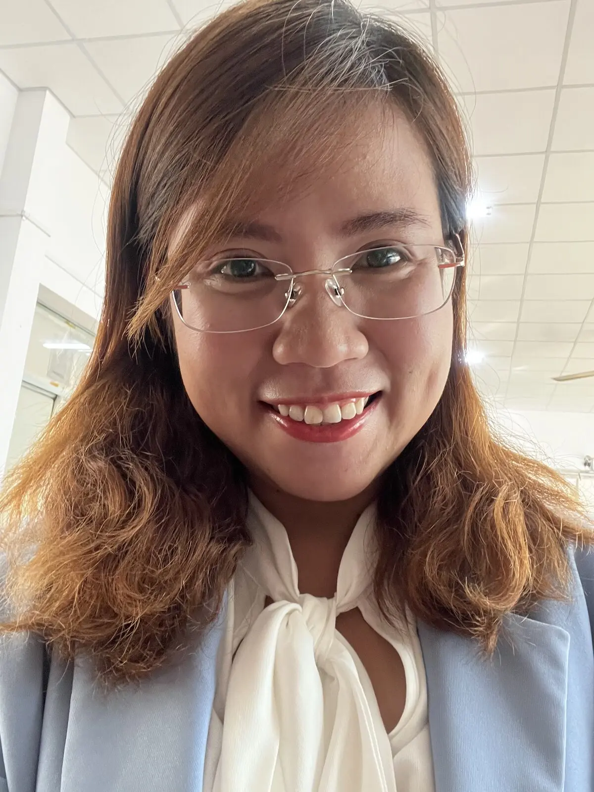 Loo cười tươi trong bộ vest xanh nhạt, đeo kính