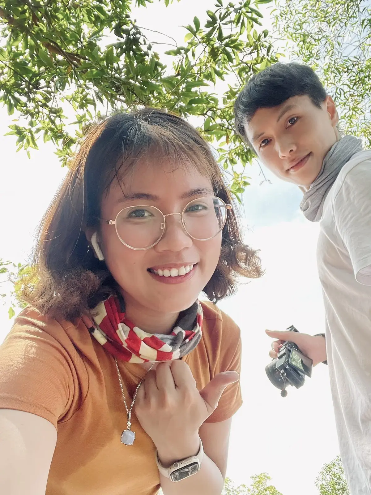Loo chụp ảnh tự sướng, tay làm hình trái tim, Boo đứng phía sau