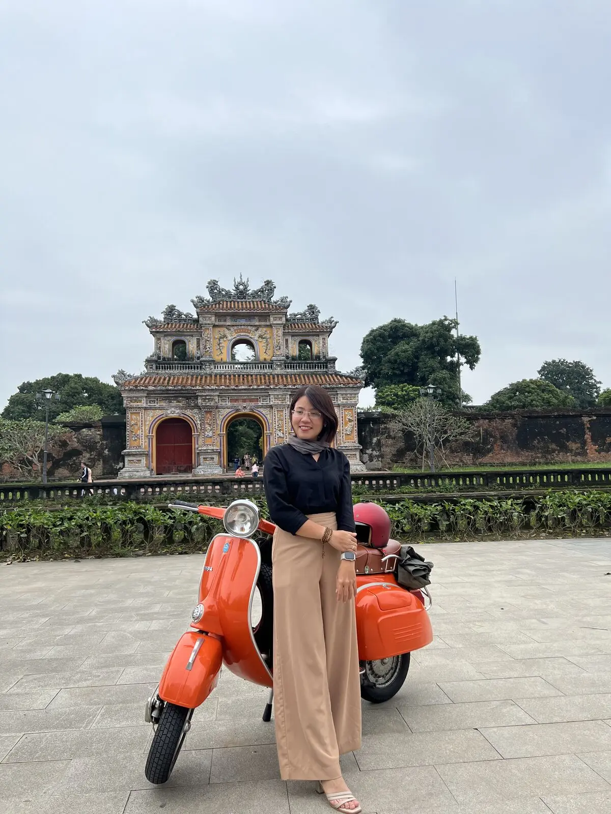 Loo đứng cạnh chiếc Vespa cam trước cửa Hiển Nhơn, Đại Nội Huế