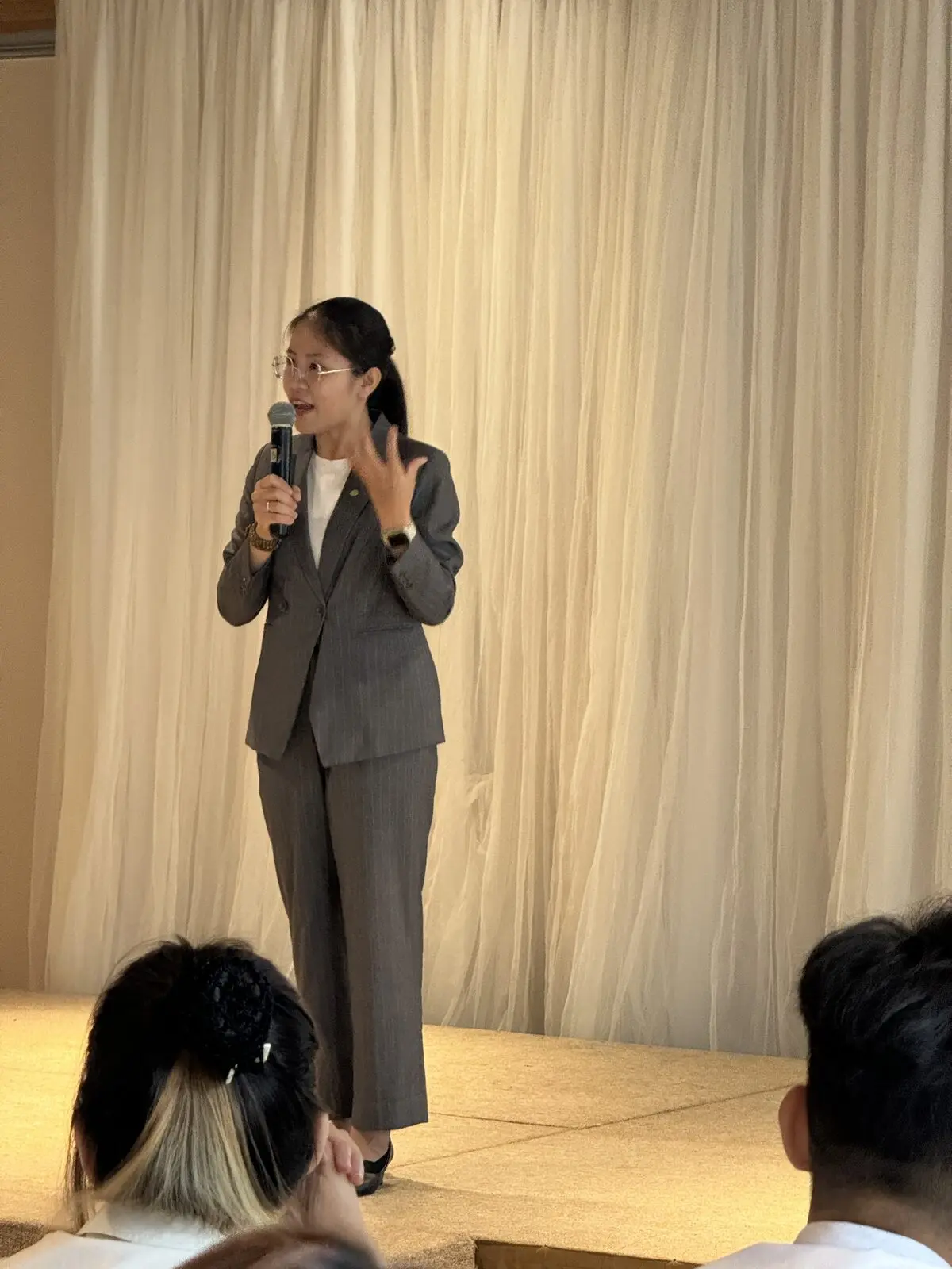 Loo cầm mic dẫn chương trình trên sân khấu một buổi workshop