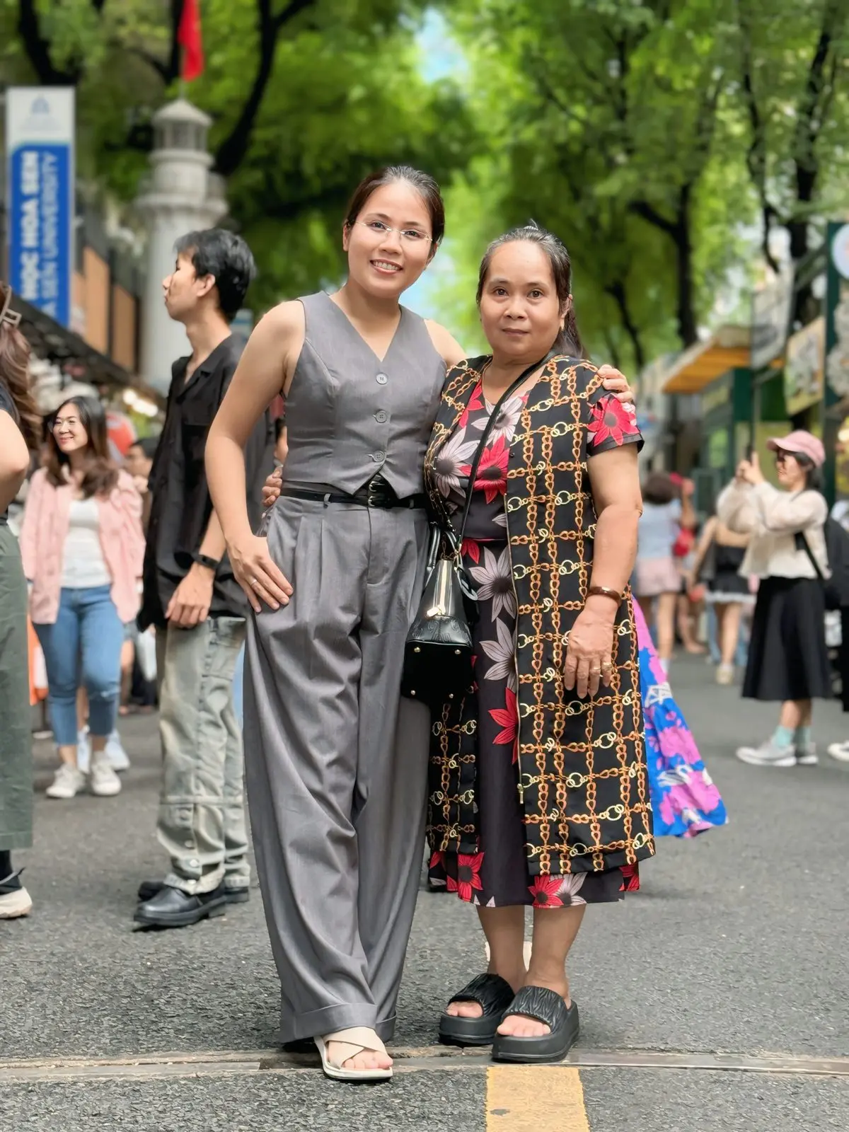 Loo và một người thân đứng trên phố đông người