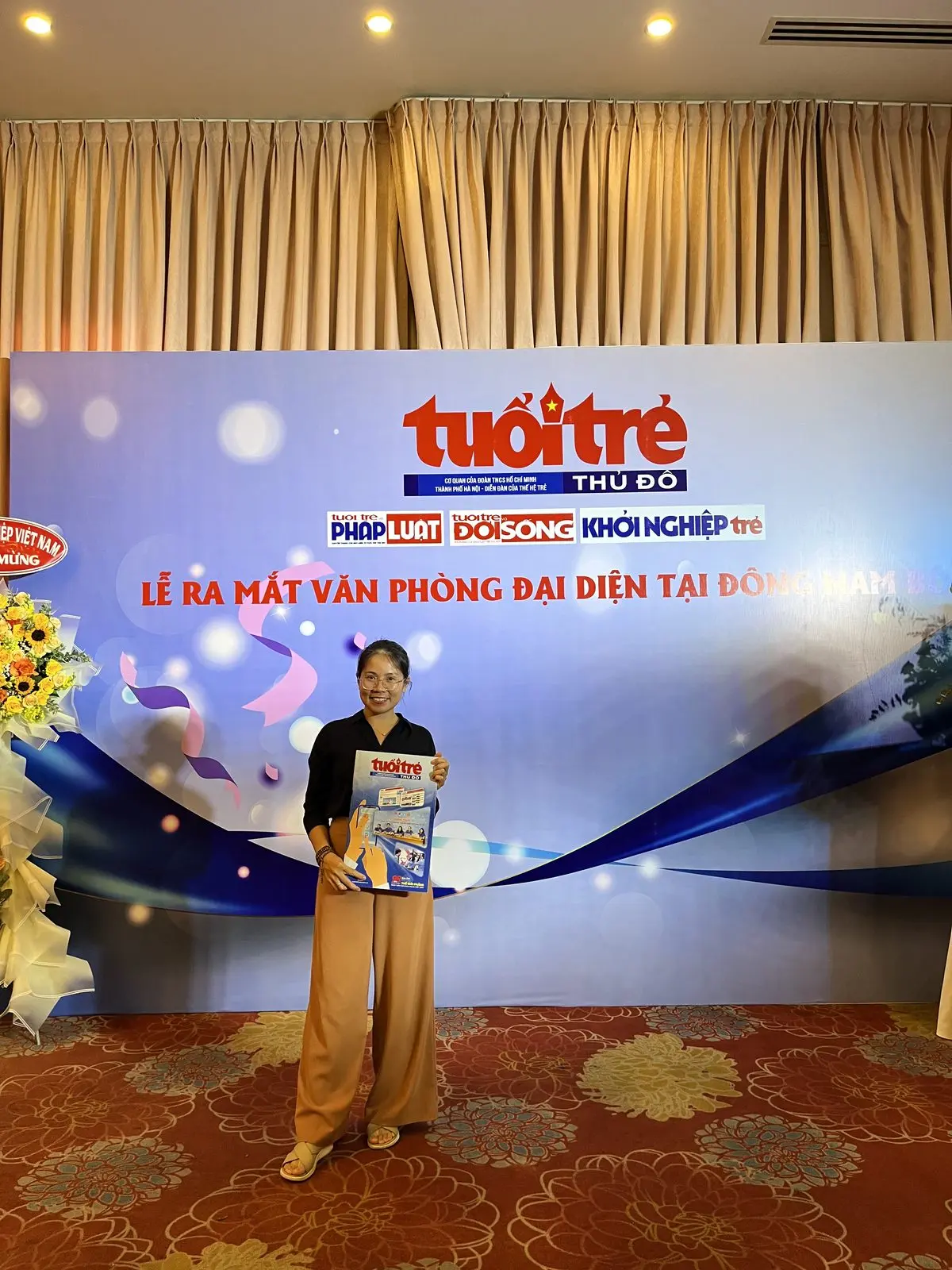 Loo cầm tờ báo Tuổi Trẻ ở lễ ra mắt văn phòng đại diện
