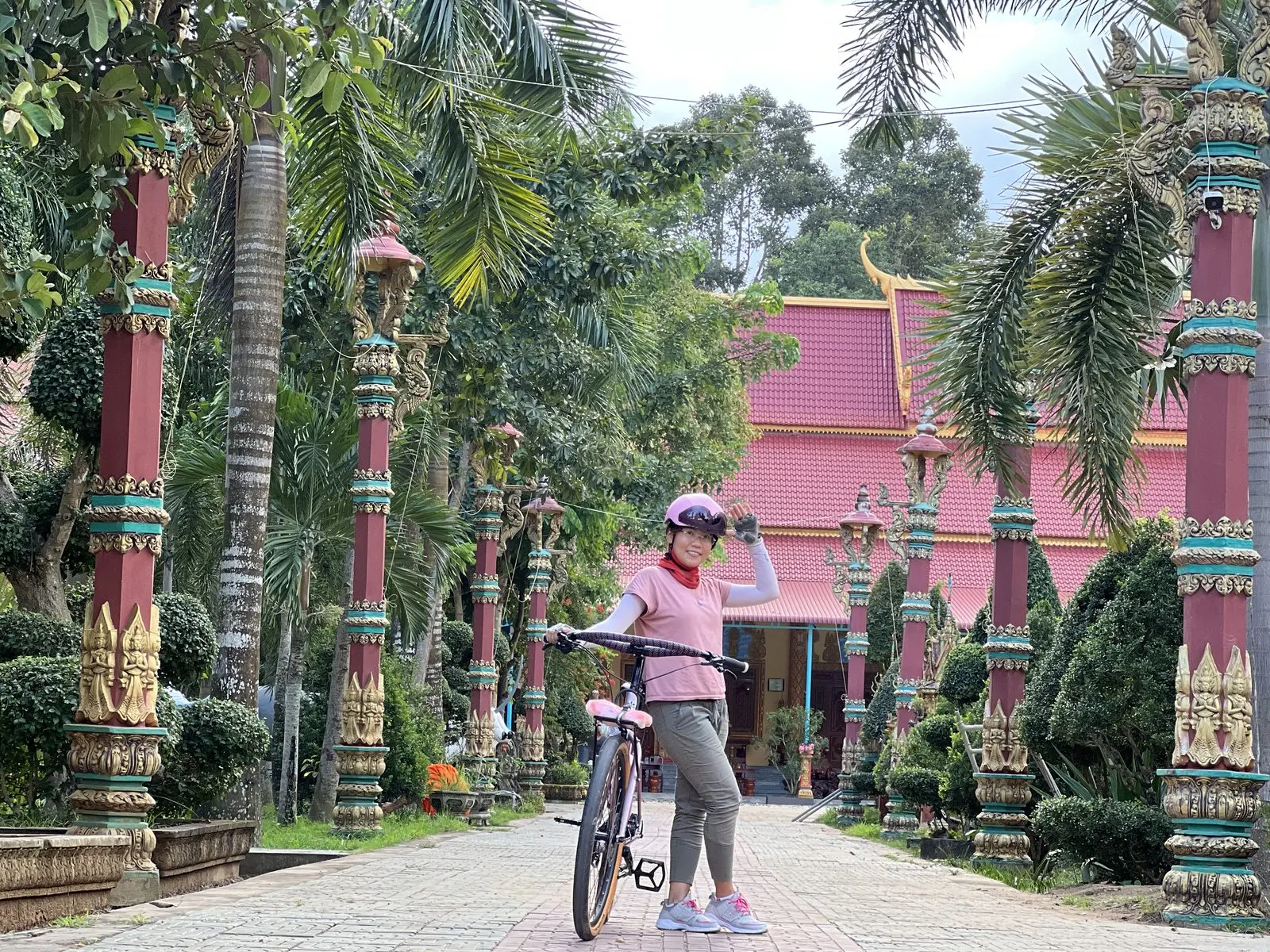 Loo dắt xe đạp trên lối vào một ngôi chùa Khmer