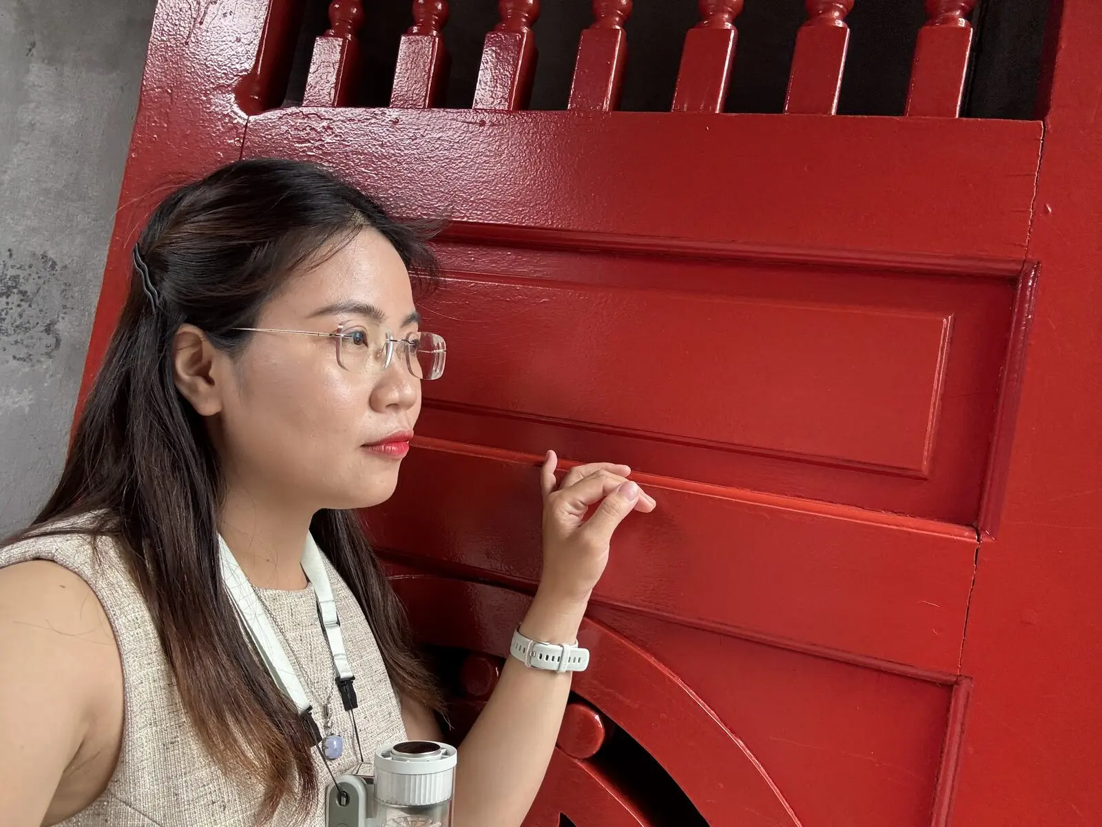 Loo đứng nghiêng bên cánh cửa gỗ đỏ ở Hà Nội