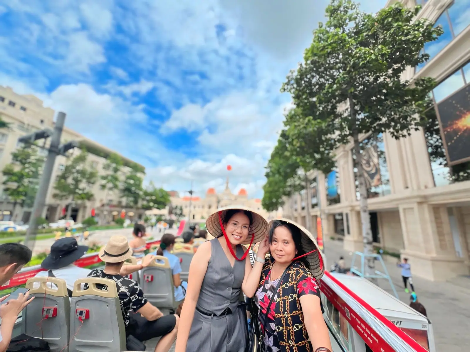 Loo và một người thân đội nón lá trên xe buýt hai tầng giữa trung tâm thành phố