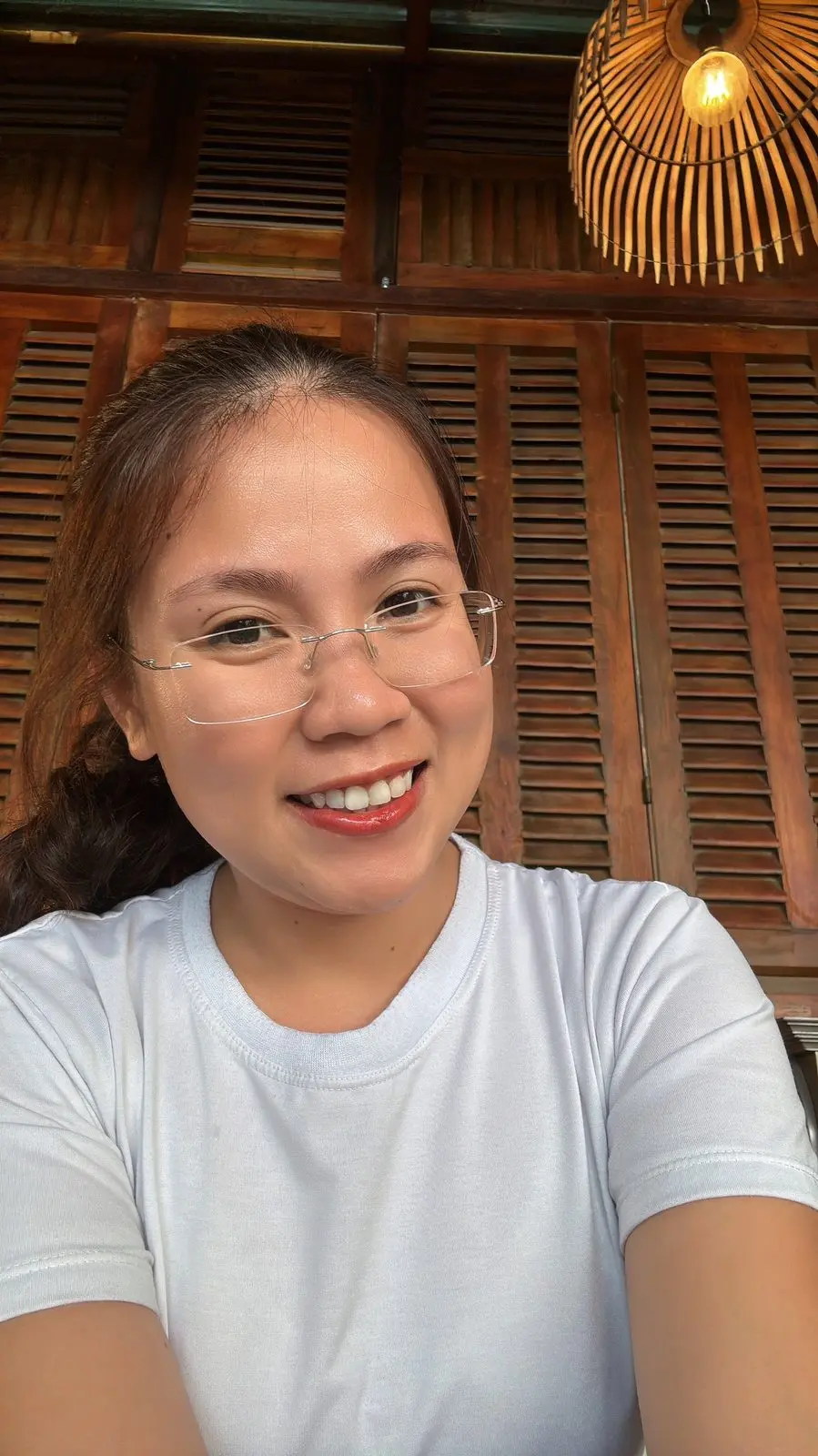 Loo mặc áo thun trắng, đeo kính, cười