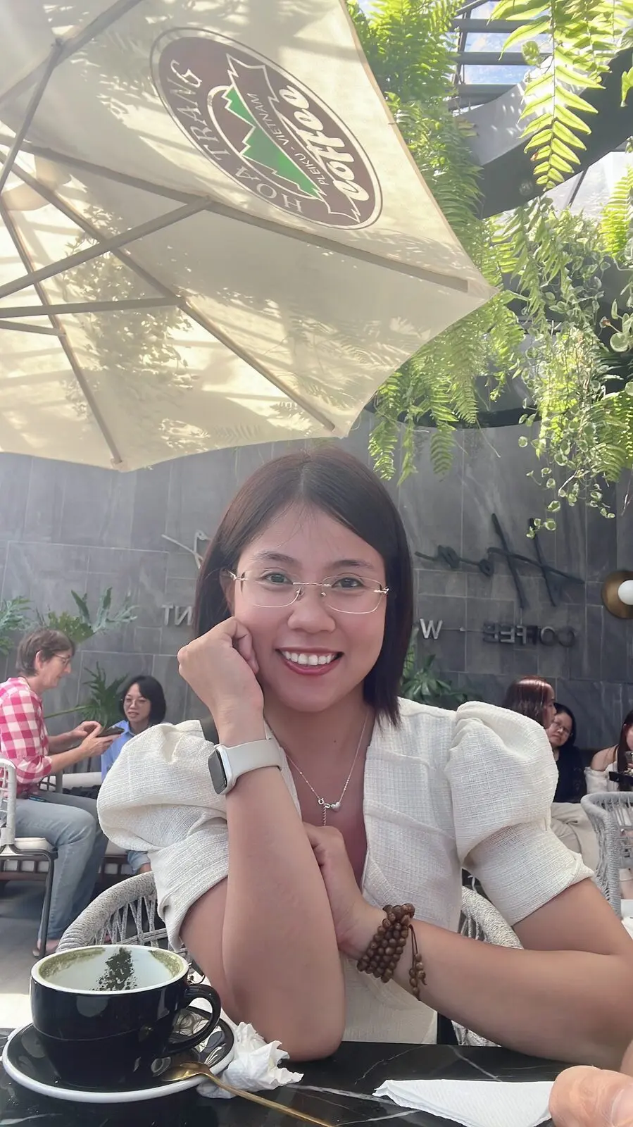 Loo chống cằm cười trong một quán cà phê